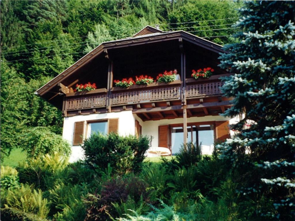 a house with a balcony with flowers on it at Apartment Vogelsinger in Ossiach
