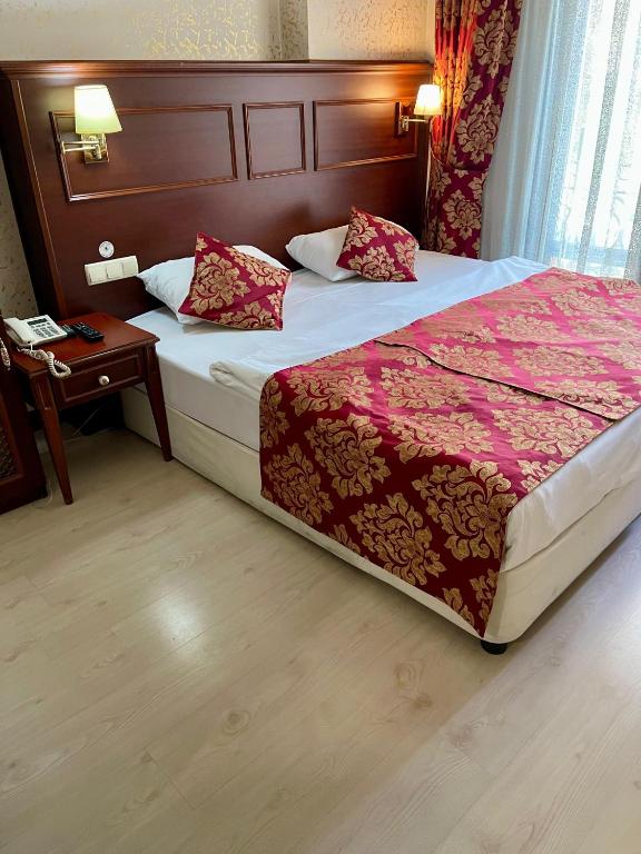 a bedroom with a bed and a table with a telephone at Istanbul Newcity Hotel in Istanbul