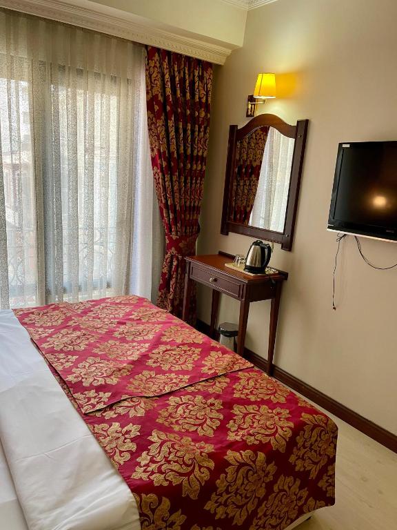 a bedroom with a bed and a mirror and a television at Istanbul Newcity Hotel in Istanbul