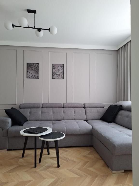 a living room with a couch and two tables at Apartament Pod Malnikiem in Muszyna