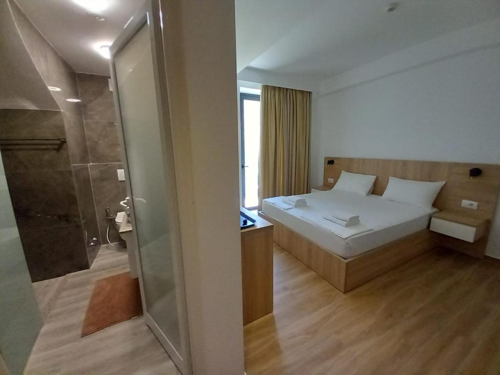 a small bedroom with a bed and a shower at Hotel Ksamili in Ksamil