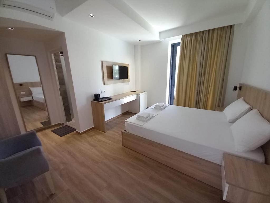 a hotel room with a bed and a television at Hotel Ksamili in Ksamil