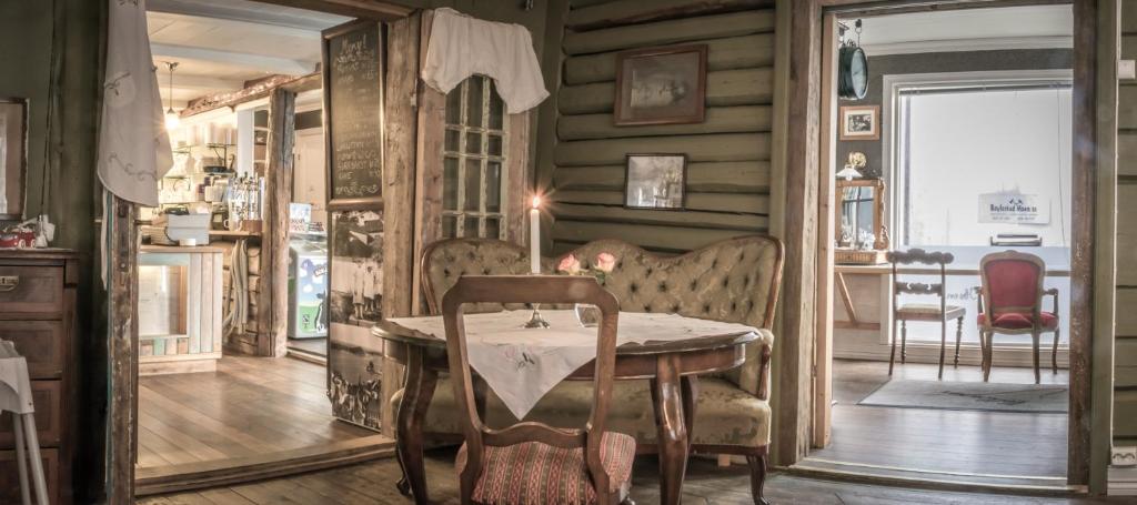 een eetkamer met een tafel en een spiegel bij Gjestehuset IBSEN in Grimstad