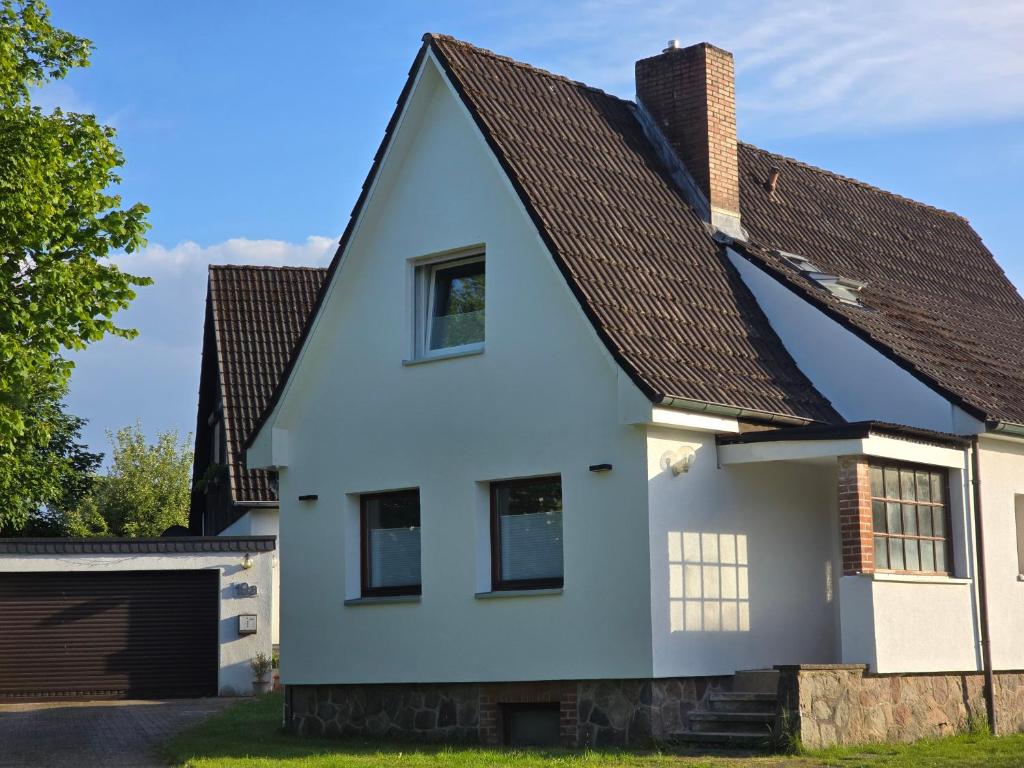 a white house with a brown roof at Ferienhaus am Großensee und Erholung vor den Toren Hamburgs in Großensee