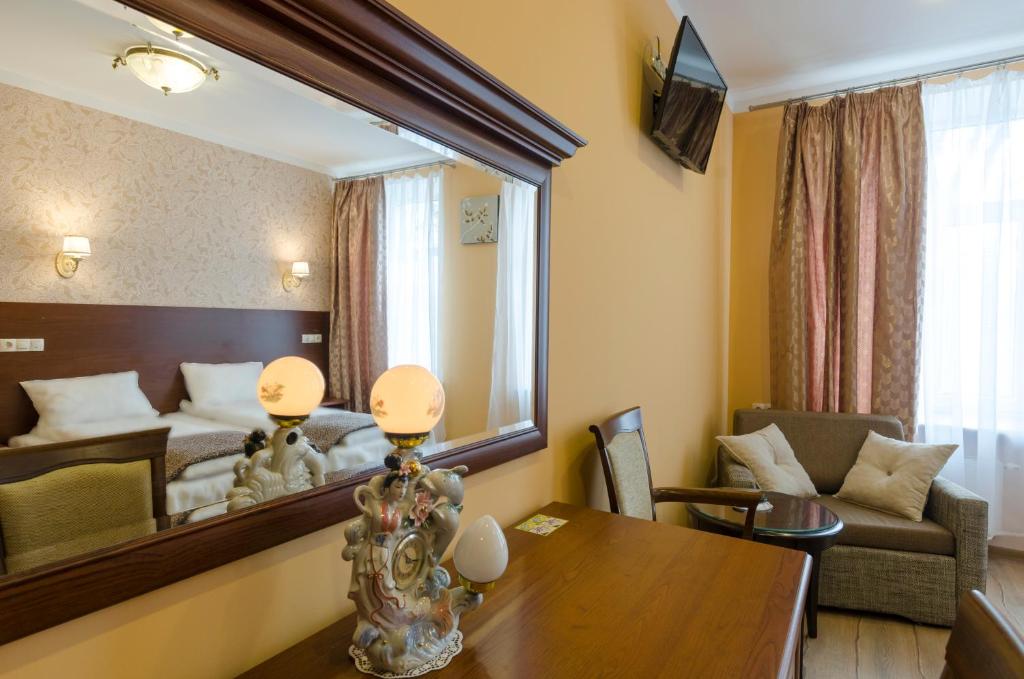 a room with a bed and a table and a mirror at Gogol Park Rooms in Riga