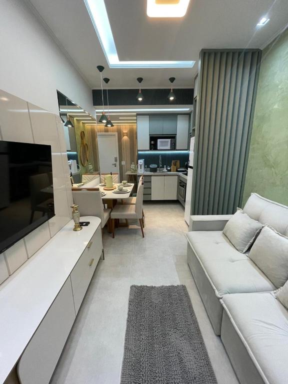 a living room with a white couch and a kitchen at Paraíso no coração da Lapa in Rio de Janeiro