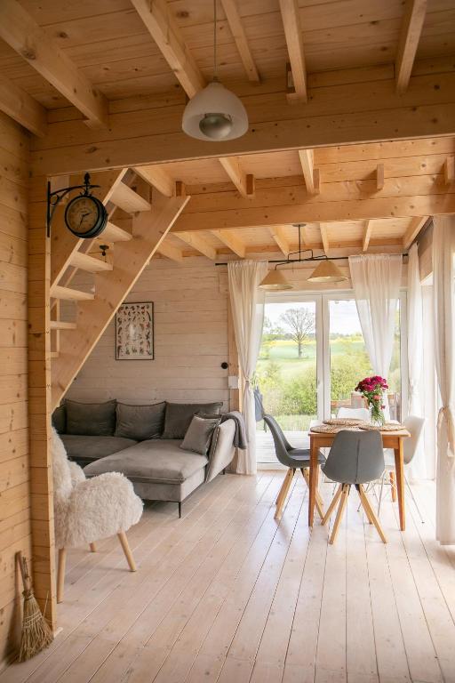 a living room with a couch and a table at Dzika Warmia- domek bez sąsiadów na Warmii z balią i kominkiem in Glebisko