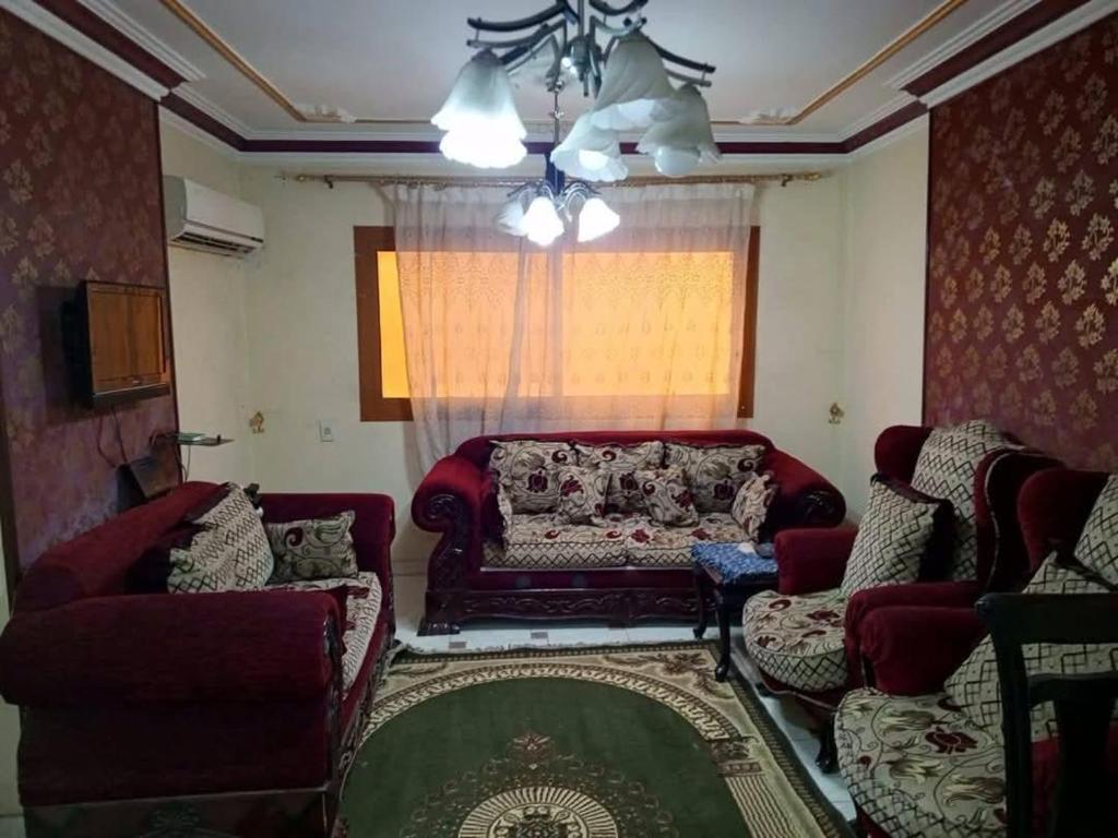 a living room with a red couch and a window at فلورس لوج 