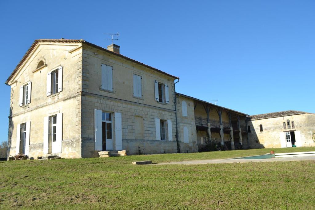 an old stone building on a grass field at Maison de maître - proche de Saint Emilion in Gardegan-et-Tourtirac