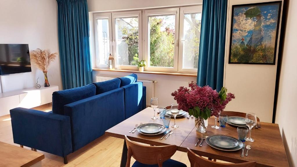 a dining room with a table and a blue couch at Rumia Cichy Zaułek 2 in Rumia