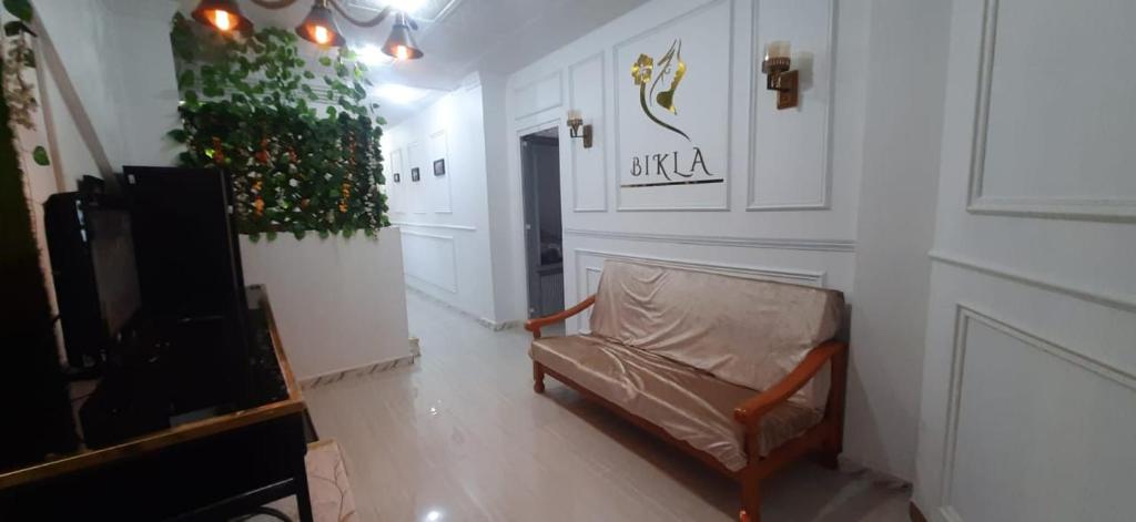 a living room with a chair and a television at bikla f3 2nd floor in Khenchela