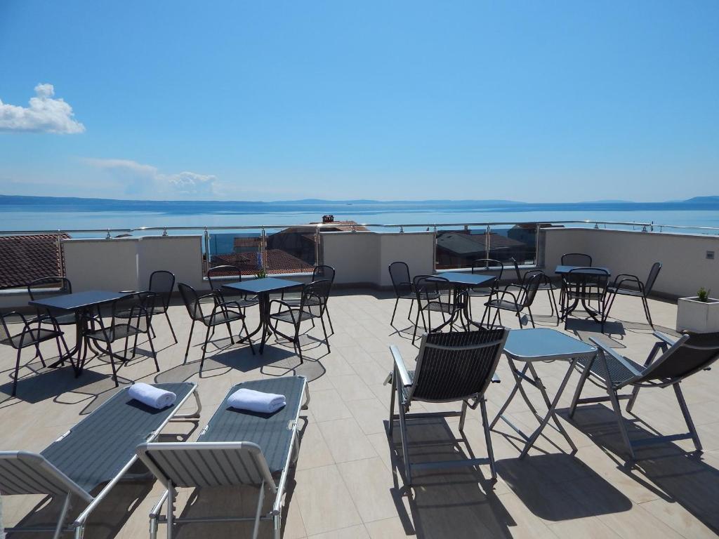 a patio with tables and chairs and the ocean at AB Villa Podstrana in Podstrana