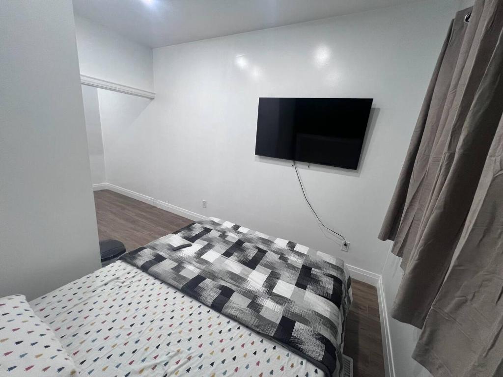 Un dormitorio con una cama y un televisor de pantalla plana en la pared. en B12 Private Room In Cambridge, en Cambridge