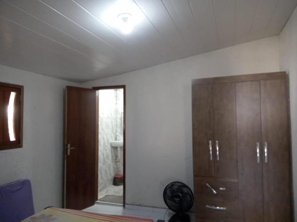 ein Schlafzimmer mit einem Bett und einem Holzschrank in der Unterkunft Granja ao lado da festa Soul João in Lagoa Sêca