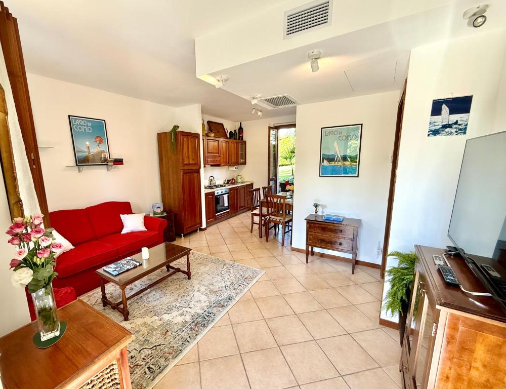 ein Wohnzimmer mit einem roten Sofa und einer Küche in der Unterkunft Casa Lago in Bellagio in Bellagio