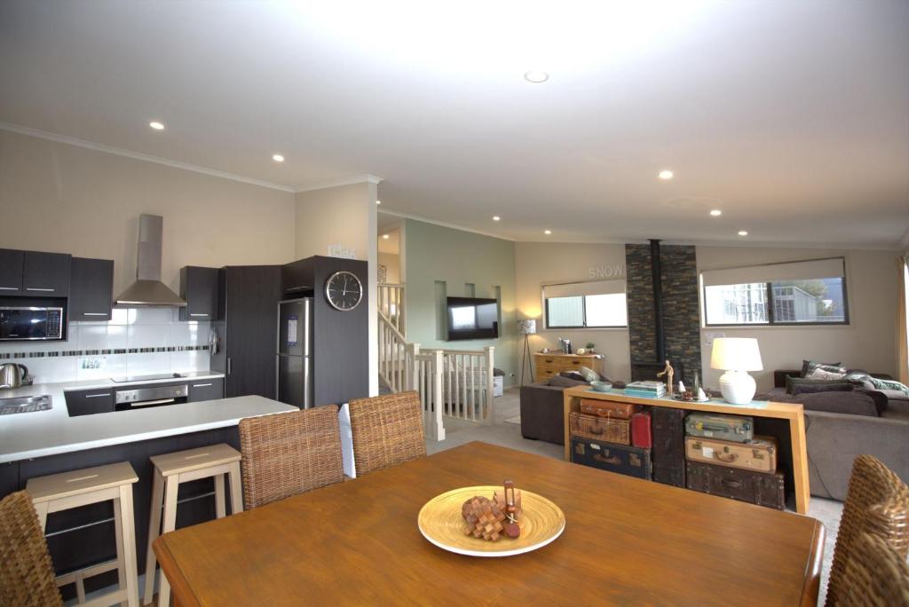 cocina y sala de estar con mesa de madera en una habitación en Boronia 7 30 Nettin Circuit, en Jindabyne