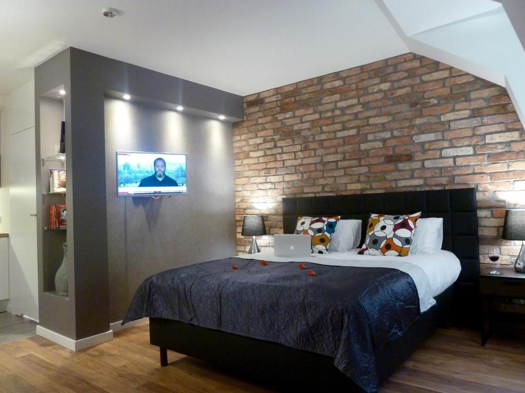 sypialnia z dużym łóżkiem i ceglaną ścianą w obiekcie Gdansk Tartaczna Premium Apartment w Gdańsku