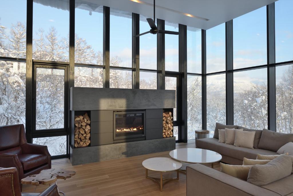 ein Wohnzimmer mit Couch und Kamin in der Unterkunft Zen Niseko in Niseko