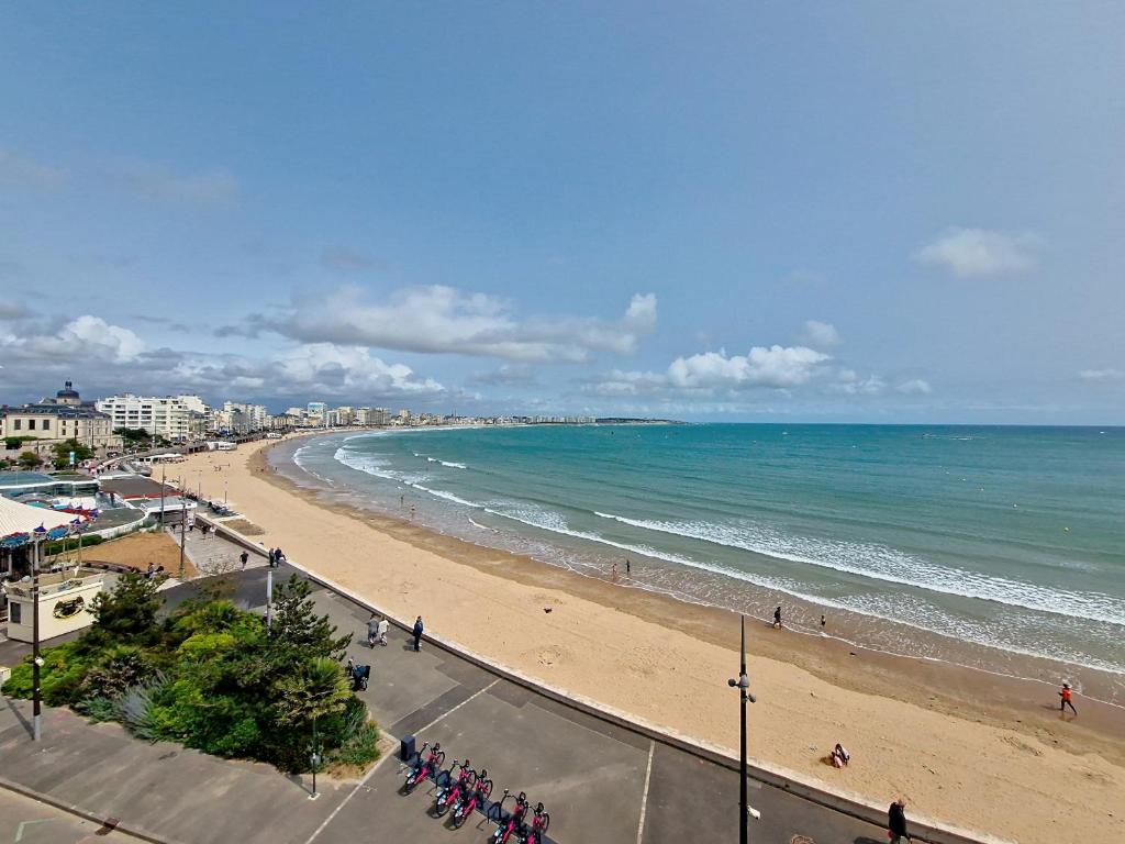 une vue d'une plage avec des gens et l'océan dans l'établissement Appartement T2 face plage, confortable, balcon, 4 pers., prox. centre, parking, ascenseur - FR-1-331-9, à Les Sables-dʼOlonne