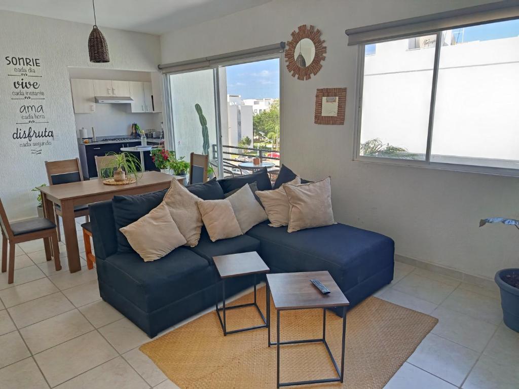 a living room with a blue couch and a table at Habitación privada en penthouse con roof top in Playa del Carmen