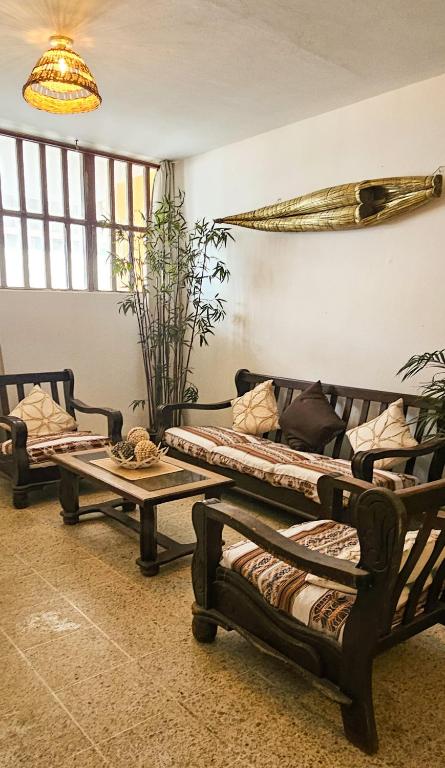 a room with two beds and a table at Yellow Surf House in Huanchaco