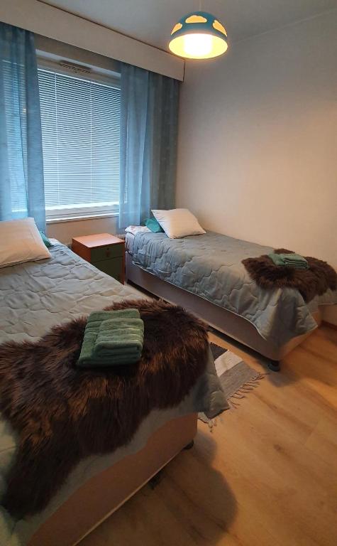 a bedroom with two beds with faux fur at Arctic way in Sodankylä