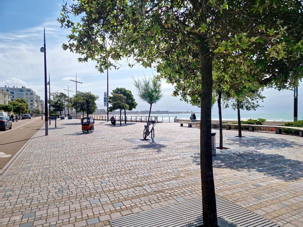 un vélo garé sur un trottoir en briques à côté de la plage dans l'établissement Appartement T2 aux Sables d'Olonne, Face Mer, 3 Pers - FR-1-331-231, à Les Sables-dʼOlonne