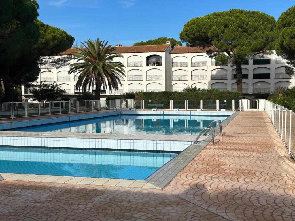 une grande piscine devant un immeuble dans l'établissement Appartement avec piscine, parking proche plage - FR-1-837-19, à Argelès-sur-Mer