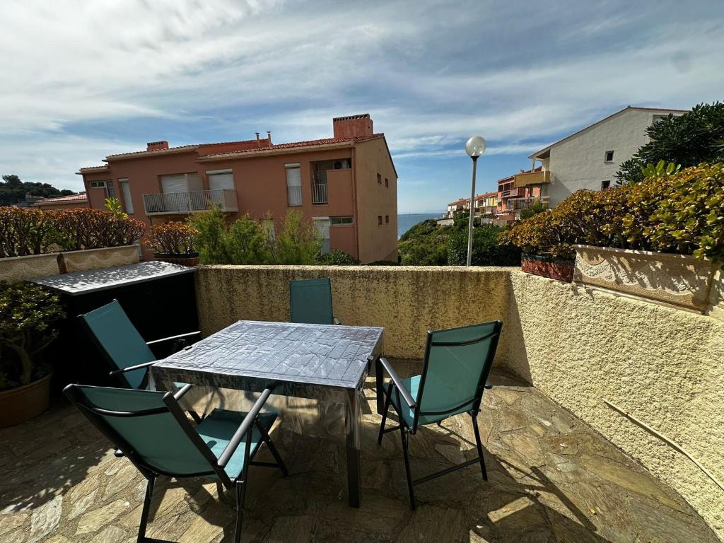 une table et des chaises sur une terrasse avec une table et des chaises dans l'établissement Appartement T3 à Collioure, 30m des plages, terrasse et parking - FR-1-309-520, à Collioure