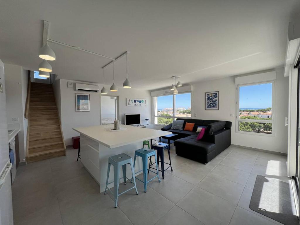 une cuisine et un salon avec un canapé et une table dans l'établissement Duplex de Standing pour 7 Pers. avec Terrasse et Parking à 500m de la Plage - FR-1-81-642, à Port-Leucate