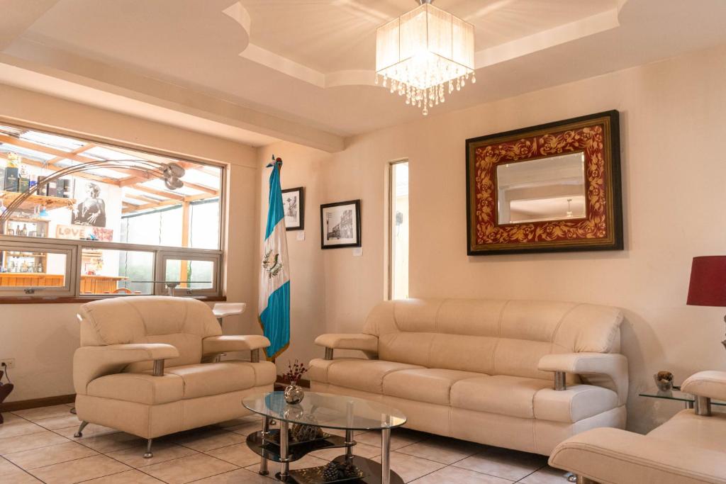 a living room with a couch and chairs and a chandelier at Hotel Casa Blanca Inn in Estación Pamplona
