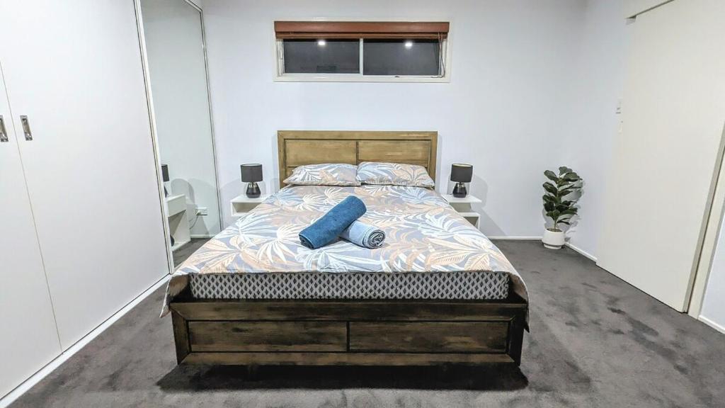 Un dormitorio con una cama con almohadas azules. en Entire Place Private Luxe 1BR with 1BA 1K 1LR, en Ingleburn