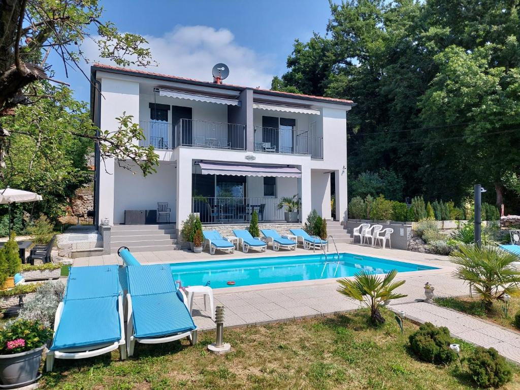 Willa z basenem i niebieskimi leżakami w obiekcie Villa Madlen w mieście Ičići