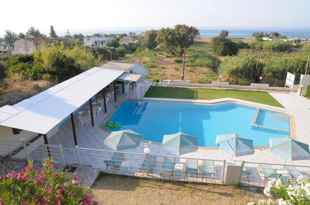 a large swimming pool with a view of the ocean at Andy's Gardens in Gerani