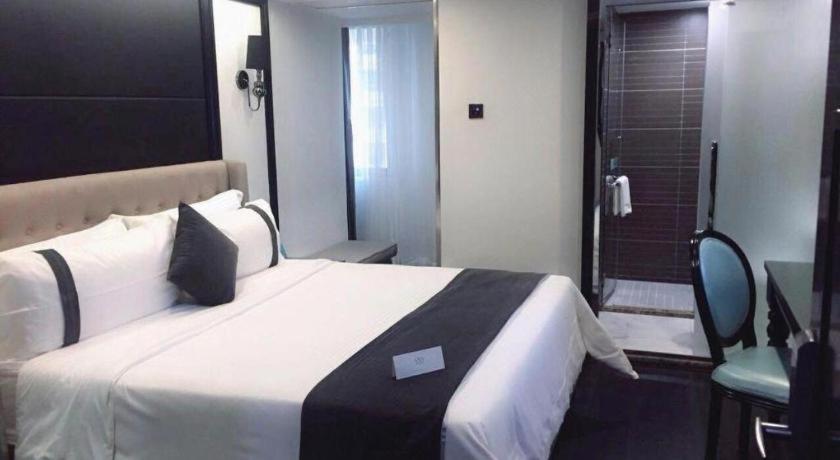 a hotel room with a large bed and a bathroom at Xana Hotelle Xiamen Airport Zone Government in Xiamen