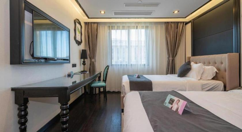 a hotel room with two beds and a desk with a mirror at Xana Hotelle Xiamen Airport Zone Government in Xiamen