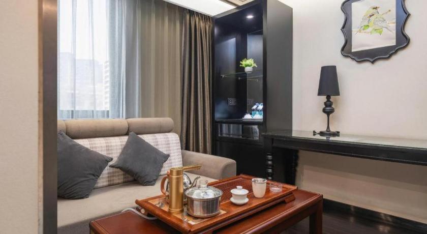 a living room with a couch and a table at Xana Hotelle Xiamen Airport Zone Government in Xiamen