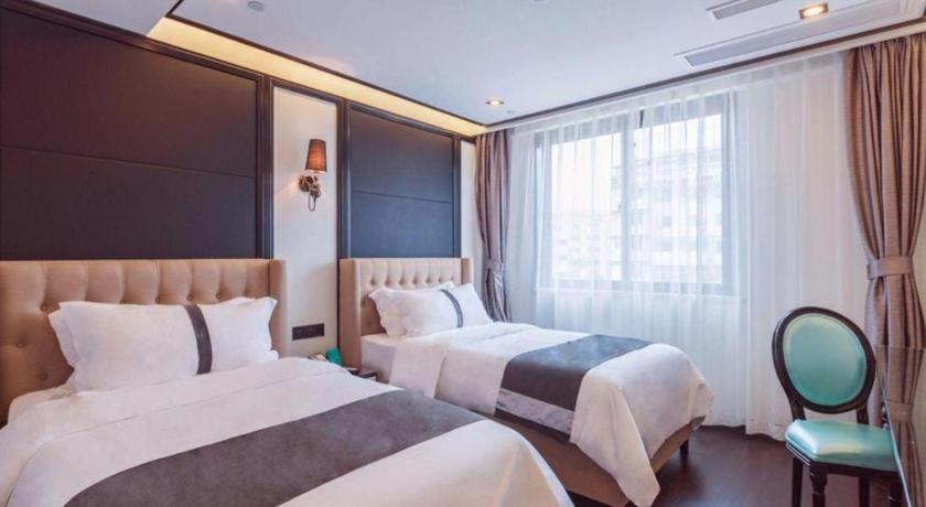 a hotel room with two beds and a window at Xana Hotelle Xiamen Airport Zone Government in Xiamen
