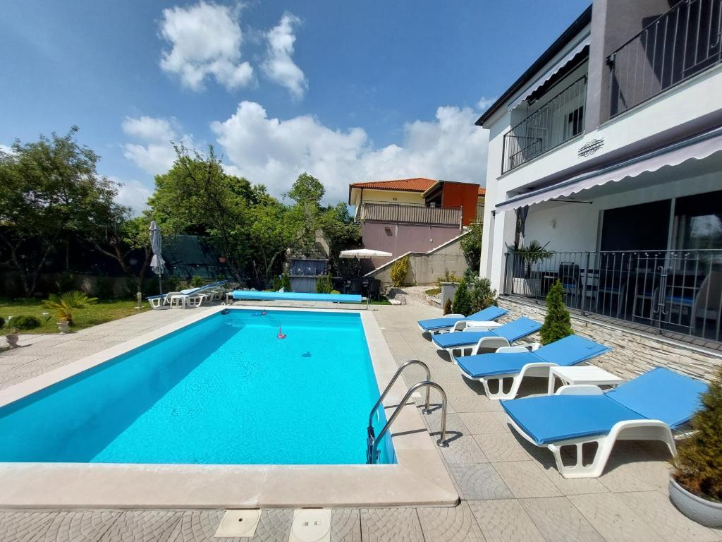 basen z leżakami obok budynku w obiekcie Villa Madlen w mieście Ičići