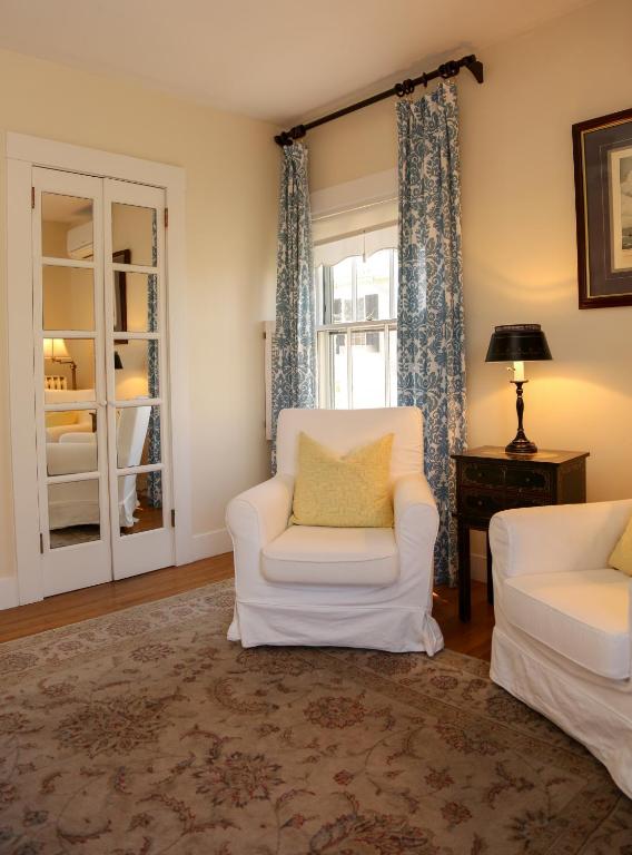 a living room with a white chair and a window at Marshall Slocum Inn in Newport
