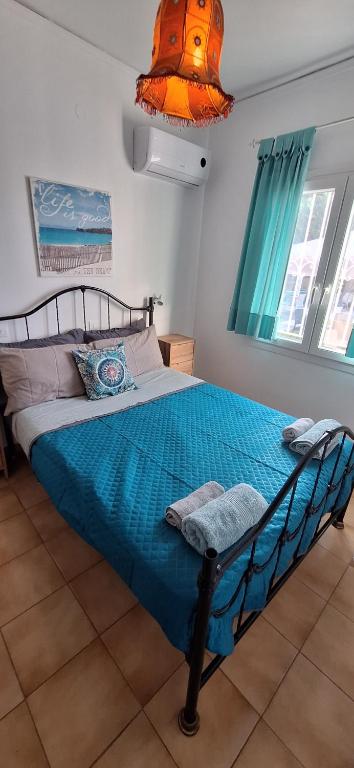 a bedroom with a bed with a blue comforter at Sausan Hotel in Sidari