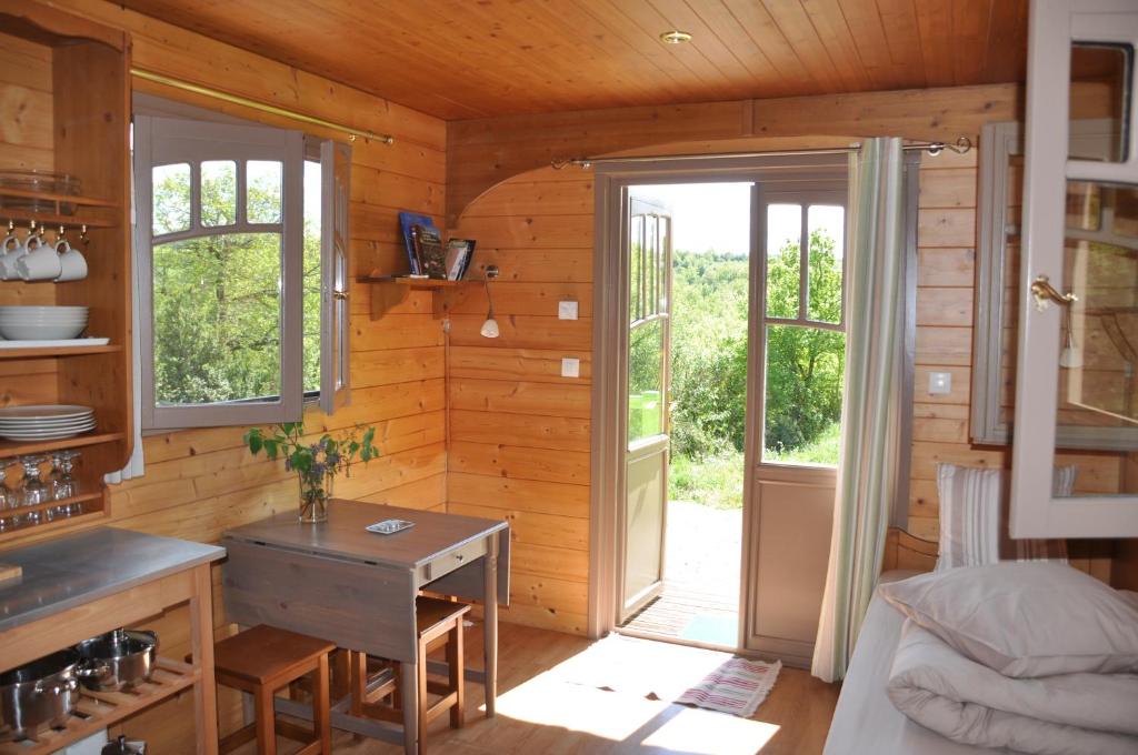 um quarto com uma cozinha e uma porta aberta em La roulotte d'Alcas em Saint-Jean-et-Saint-Paul