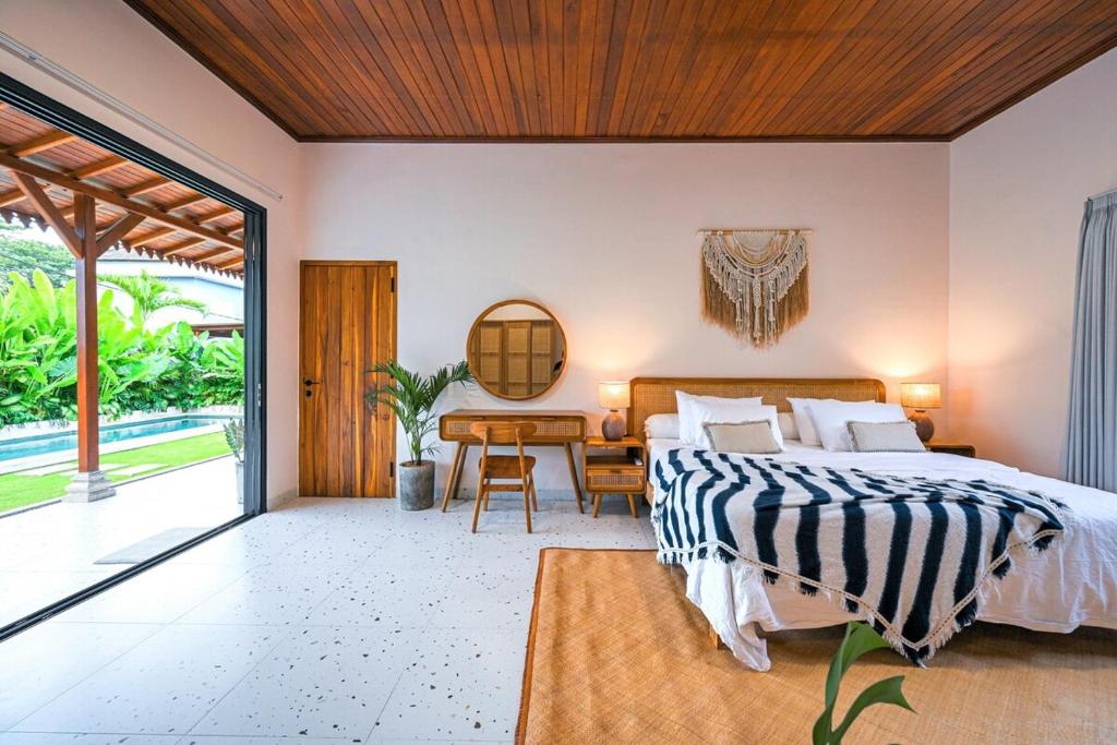 ein Schlafzimmer mit einem großen Bett und einem Schreibtisch in der Unterkunft Luxury 2BR Tropical Villa in Jimbaran, Bali in Jimbaran