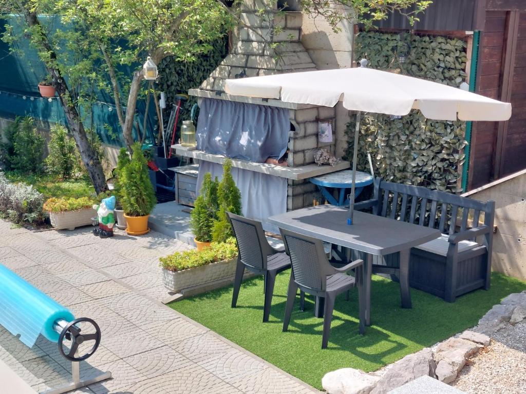stół, krzesła i parasol na dziedzińcu w obiekcie Villa Madlen w mieście Ičići