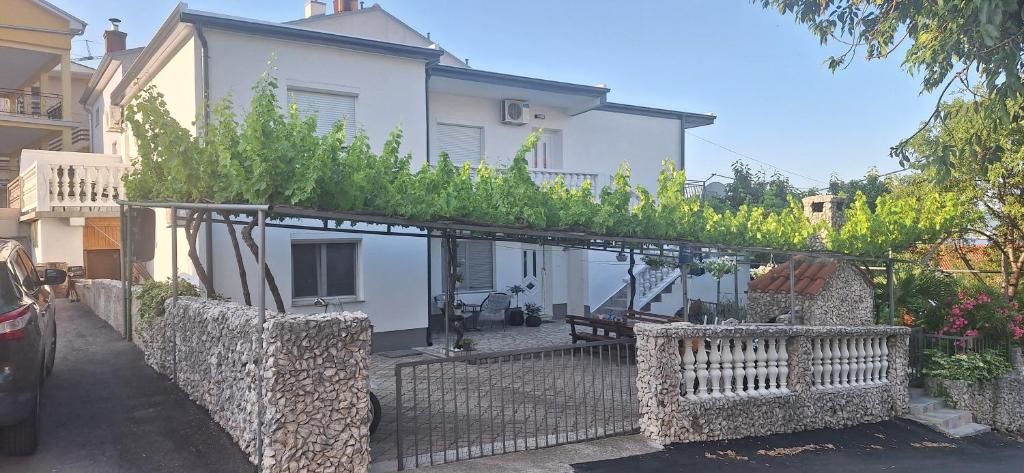 eine Pergola mit Pflanzen darauf vor einem Haus in der Unterkunft Apartments Jamice in Novi Vinodolski