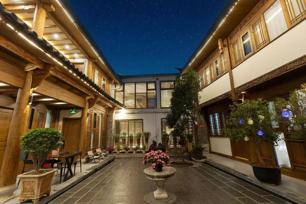 Un patio de un edificio con plantas en macetas. en Crazy Stone Inn, en Lijiang