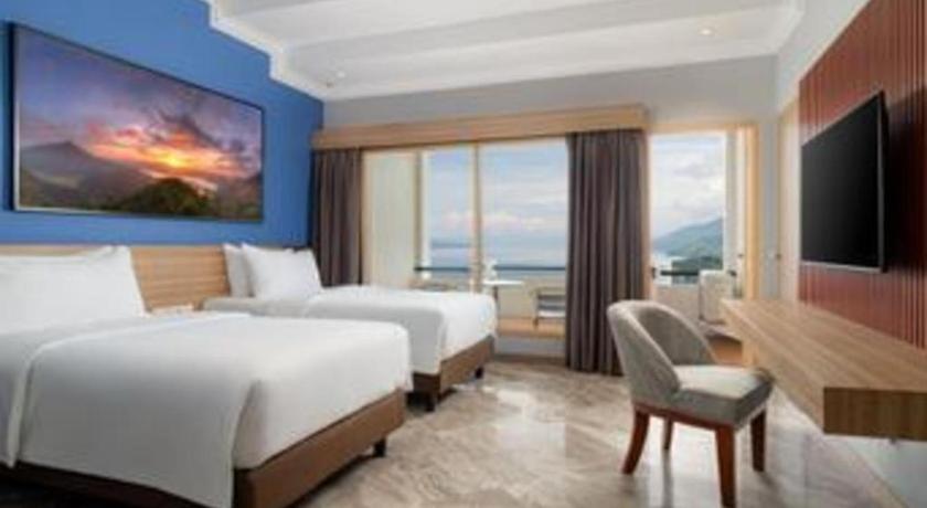 a hotel room with two beds and a television at Hotel Niagara Parapat in Parapat