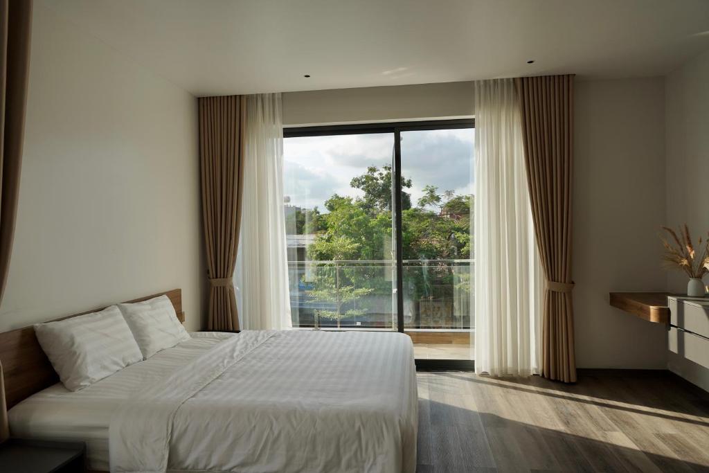 Ðông KhêにあるMiami Luxury Apartment Hai Phongのベッドと大きな窓のある寝室