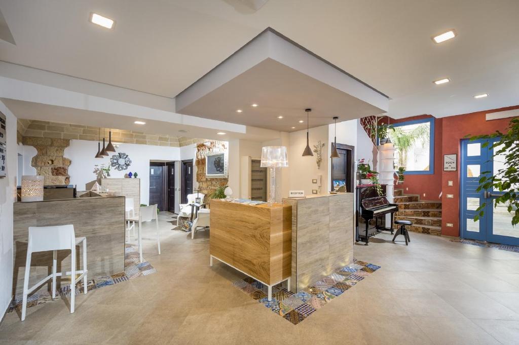 a living room with a kitchen and a dining room at Hotel Vento del Sud in San Vito lo Capo