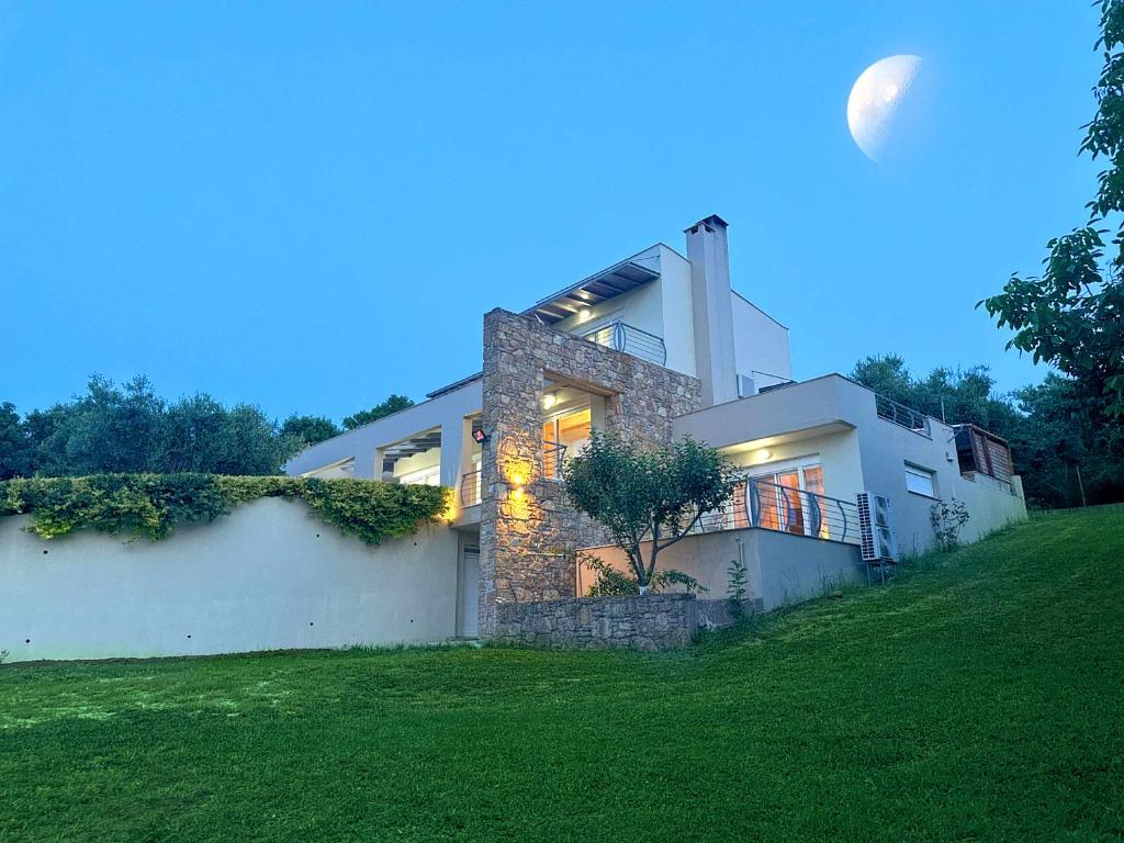 a large white house with the moon in the sky at Sunrise Villa in Kassandra